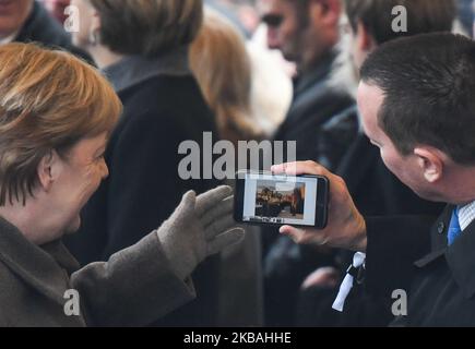 The US ambassador to Germany Richard Grenell (Right) shows picture of a unveilled statue of Ronald Reagan at the American embassy in Berlin on his mobile phone to German Chancellor Angela Merkel (Left), as they arrive to attend the central commemoration ceremony for the 30th anniversary of the fall of the Berlin Wall, at the Berlin Wall Memorial at Bernauer Strasse in Berlin. On Saturday, November 9, 2019, in Berlin, Germany. (Photo by Artur Widak/NurPhoto) Stock Photo