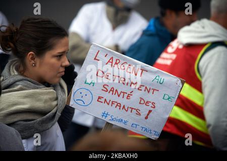 A nurse holds a placard reading 'Money at detriment of children health'. All professionnals from french public hospitals took to the streets for another day of action as they are on strike for the 6th month in a row. Physicians say that emergency services and more generally all services even children' hospitals are beyond saturation point. They denounce a reduction of people in public hospitals and demand 10 000 nurses more. French government demand public hospitals to save €1billion for 2020. Hospitals have already saved more than €10billions since 2010. Toulouse. France. November 14th 2019.  Stock Photo