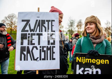 Two Anti -Black Piet activists holding banners during the arrival of Sinterklaas to Nijmegen, on November 16th, 2019. (Photo by Romy Arroyo Fernandez/NurPhoto) Stock Photo