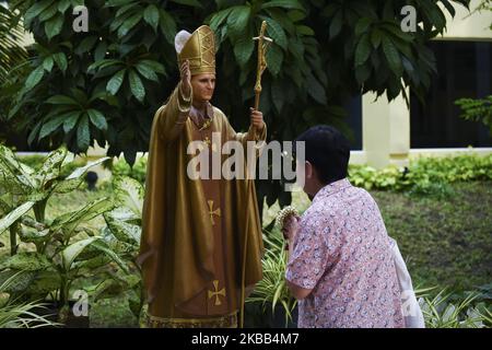 A Thai Catholic devotee prays before a statue of Pope John Paul II at Saint Louis Church in Bangkok, Thailand, 17 November 2019 (Photo by Anusak Laowilas/NurPhoto) Stock Photo