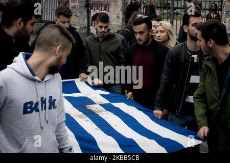 Students wear a blood-stained Greek flag with roses, which was in the National Technical University in Athens, Greece on November 17, 2019 during a demonstration on the 46th anniversary of Polytechnic school, uprising against the military Junta that was ruling Greece in 1993. (Photo by Nikolas Kokovlis/NurPhoto) Stock Photo