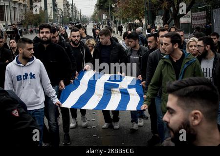 Students wear a blood-stained Greek flag with roses, which was in the National Technical University in Athens, Greece on November 17, 2019 during a demonstration on the 46th anniversary of Polytechnic school, uprising against the military Junta that was ruling Greece in 1993. (Photo by Nikolas Kokovlis/NurPhoto) Stock Photo