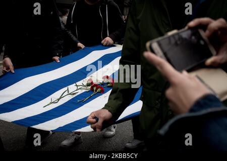 Students wear a blood-stained Greek flag with roses, which was in the National Technical University in Athens, Greece on November 17, 2019 during a demonstration on the 46th anniversary of Polytechnic school, uprising against the military Junta that was ruling Greece in 1993. (Photo by Nikolas Kokovlis/NurPhoto) Stock Photo