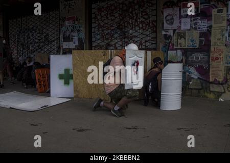 Volunteer doctors use shields to protect against the actions of the police in Santiago de Chile on November 21, 2019. (Photo by Claudio Abarca Sandoval/NurPhoto) Stock Photo