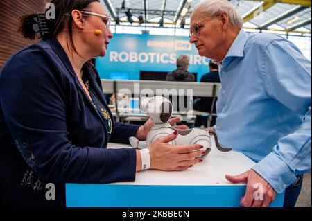 Two people are talking while in the middle is Aibo robot of Sony, during the Bright Day Festival in Amsterdam, on November 23rd, 2019. (Photo by Romy Arroyo Fernandez/NurPhoto) Stock Photo