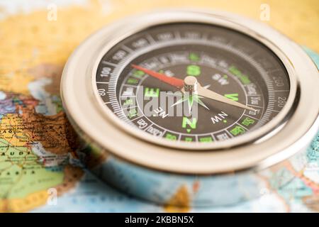 Bangkok, Thailand - January 20, 2022  Compass for navigation on  world map background to travel, geography, tourism and exploration concept. Stock Photo