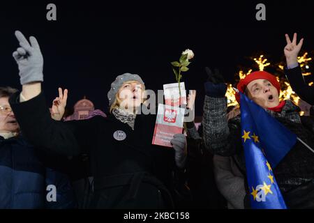 A man holds EU and Polish flags during another solidarity with harrassed judges protest In Krakow's Main Martket Square. A few hundreds people, mainly members of Krakow's Committee for the Defence of Democracy (Polish: KOD) and their supporters, joined this evening other protesters accross the country to express their solidarity with judges during 'We Do It For Everyone - Solidarity With Judges!' protest. On Sunday, December 1, 2019, in Krakow, Poland. (Photo by Artur Widak/NurPhoto) Stock Photo