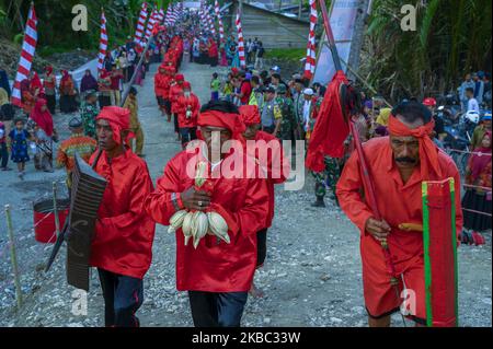 The Batui indigenous people are accompanied by local residents carrying ...