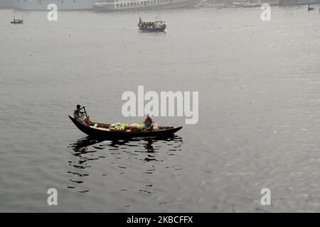 Bangladeshi boats man paddles his row boat with passengers on the polluted Buriganga River in Dhaka, Bangladesh, on December 09, 2019. (Photo by Mamunur Rashid/NurPhoto) Stock Photo