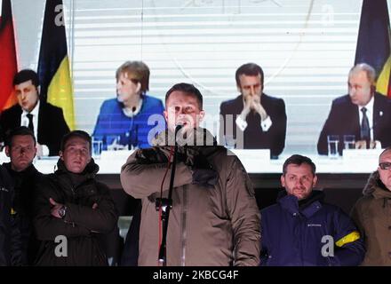 Ukrainians watch on a screen a press-conference of the Normandy Four leaders, during a rally near the Ukrainian President Volodymyr Zelensky Office in Kyiv, Ukraine, on 10 December, 2019, during the Normandy Format summit which was held on December 9 in Paris. The meeting of Normandy Four leaders, Ukrainian President Volodymyr Zelensky, Russian President Vladimir Putin, German Chancellor Angela Merkel and French President Emmanuel Macron, held in Paris on 9 December 2019. (Photo by STR/NurPhoto) Stock Photo