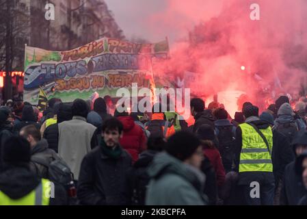 Looking at the procession of demonstrators walking behind a large banner that reads 'Public, Privé, tous ensemble jusqu'au retrait' and in the middle of the red smoke on Thursday, December 12, 2019, the day after the Prime Minister's announcements on pension reform and on the eighth day of the strike against the reform, the unions called for a third day of demonstration to demonstrate their refusal. A few thousand people answered the call, mainly railway workers from SNCF and RATP, professors, students and CGT trade unionists. (Photo by Samuel Boivin/NurPhoto) Stock Photo