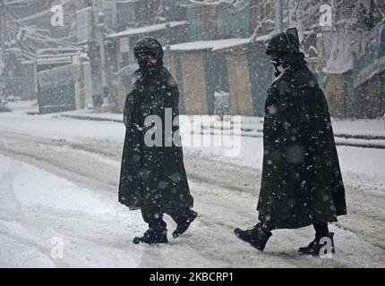 Indian paramilitary soldiers walk in Srinagar as heavy snowfall continues across Kashmir on December 13, 2019.Flight operations at Srinagar Airport remained affected for seventh straight day due to low visibility even as rain and snow lashed the Kashmir valley.The traffic on Srinagar-Jammu National highway was closed after snowfall on the highway caused slippery conditions. (Photo by Faisal Khan/NurPhoto) Stock Photo