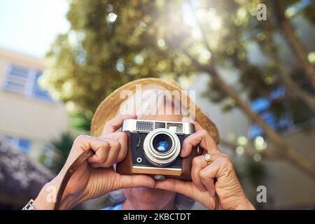 Keep capturing the moments. a senior woman taking photographs at home. Stock Photo