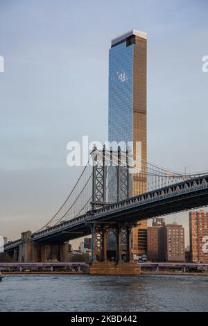 Early morning view of the iconic Manhattan Bridge from as seen from Dumbo district neighborhood in Brooklyn, NYC, USA on 14 November 2019. The 448m. long suspension bridge is a NY city landmark, tourist attraction, crossing East River and connecting Lower Manhattan to Downtown Brooklyn. The metallic iron bridge is active with traffic, 7 lanes of roadway and 4 train tracks for the subway and bicycles. It was opened to traffic in 1909, built by Phoenix Bridge Company and designed by Leon Moisseiff. (Photo by Nicolas Economou/NurPhoto) Stock Photo