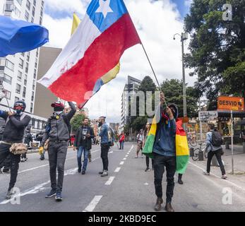 Protester loads the flag of Chile and Bolivia in the march during the national strike on December 19, 2019 in Bogota, Colombia. (Photo by Daniel Garzon Herazo/NurPhoto) Stock Photo