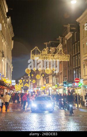 Christmas Decoration in the city center of Amsterdam in The Netherlands with thousands of tourists and visitors going shopping, walking in the streets with bags and taking pictures with the illuminated traditional buildings and festive installations. December 19, 2019 - Amsterdam, Netherlands (Photo by Nicolas Economou/NurPhoto) Stock Photo