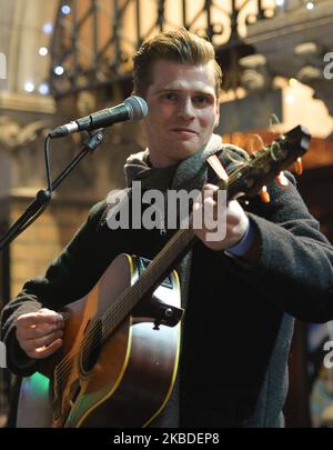 Alfie Hudson-Taylor performs in the annual Christmas Eve busk in aid of the Dublin Simon Community outside the Gaiety Theater in Dublin. Hundreds attended the annual busking concert hoping to see the U2 front man Bono. On Tuesday, 24 December 2019, in Dublin, Ireland. (Photo by Artur Widak/NurPhoto) Stock Photo