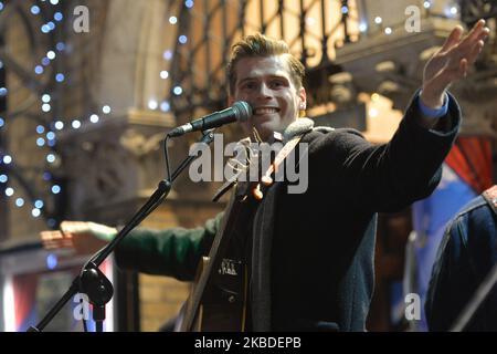 Alfie Hudson-Taylor performs in the annual Christmas Eve busk in aid of the Dublin Simon Community outside the Gaiety Theater in Dublin. Hundreds attended the annual busking concert hoping to see the U2 front man Bono. On Tuesday, 24 December 2019, in Dublin, Ireland. (Photo by Artur Widak/NurPhoto) Stock Photo