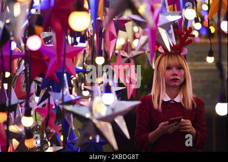 A people poses for photo as Christmas decorations and New Year on display outside an shopping mall in Bangkok, Thailand, 26 December 2019. (Photo by Anusak Laowilas/NurPhoto) Stock Photo