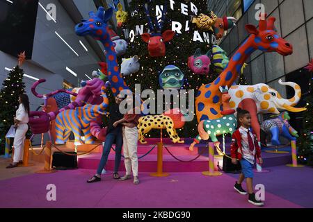 A people poses for photo as Christmas decorations and New Year on display outside an shopping mall in Bangkok, Thailand, 26 December 2019. (Photo by Anusak Laowilas/NurPhoto) Stock Photo