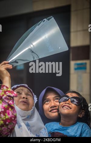 Indonesian muslims use X-ray picture to watch the annular solar eclipse at the Al-Fallah Mosque in Mojokerto, East Java on December 26, 2019. (Photo by WF Sihardian/NurPhoto) Stock Photo