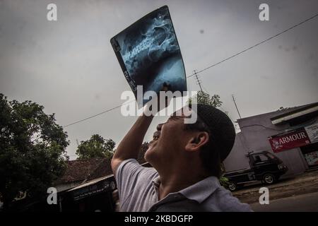 Indonesian muslims use X-ray picture to watch the annular solar eclipse at the Al-Fallah Mosque in Mojokerto, East Java on December 26, 2019. (Photo by WF Sihardian/NurPhoto) Stock Photo
