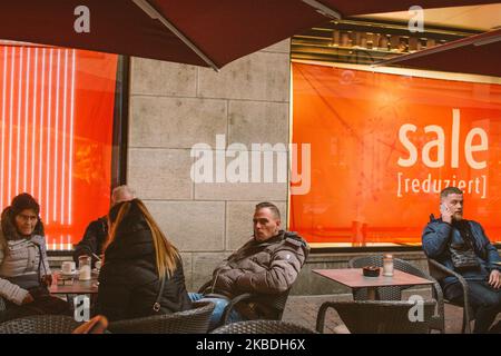 People sit in a street cafe in the city center of Cologne, Germany, on December 26, 2019. (Photo by Ying Tang/NurPhoto) Stock Photo