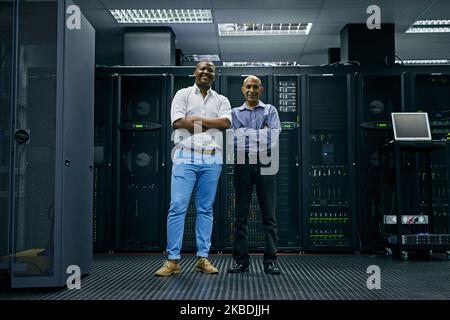 IT support at your service. Portrait of two confident IT technicians working in a data center. Stock Photo