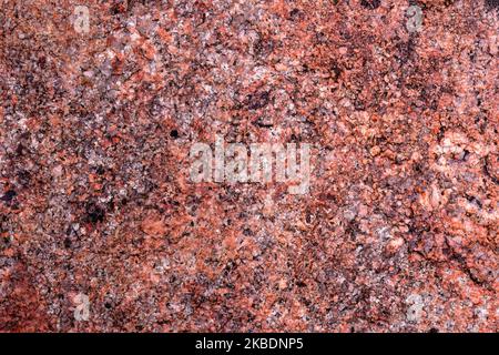 Red granite rock close up background Stock Photo