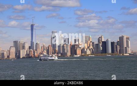 Panoramic view of New York City skyscrapers of (Lower Manhattan) with passenger boat on the foreground, USA Stock Photo