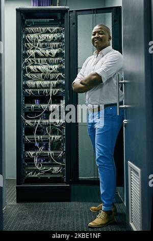 He sets the standard for quality IT support. Portrait of a confident IT technician working in a data center. Stock Photo
