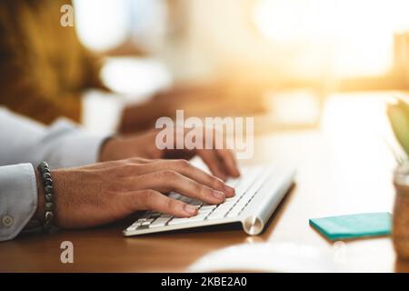 Always connected. Always online. Always ready to help. an unrecognizable man typing on a keyboard. Stock Photo