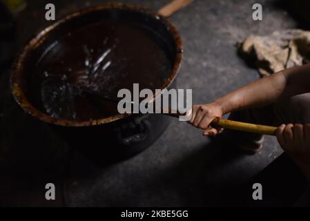 Workers whipping semi Hard molasses to molasses Chaku at Tokha, Kathmandu, Nepal on January 10, 2020. Molasses Chaku is usually prepared and consumed during the Maghe Sankranti Festival and throughout winter by Nepalese. It is believed that consuming Chaku promotes good health and warmth in the cold months. In the market shopkeeper sells 250 grams of Chaku at Rs 40 to 50, depending on the ingredients used. (Photo by Narayan Maharjan/NurPhoto) Stock Photo