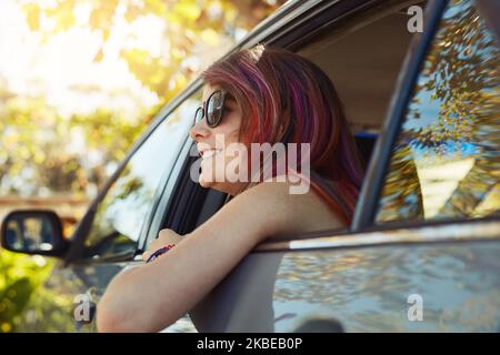 I love this fresh air. young woman taking a break and enjoying nature while sitting in the backseat of a car. Stock Photo