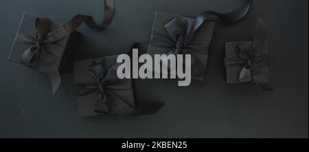 Black Friday Sale and Christmas presents. Gift boxes with satin ribbon and bow, banner, top view. Stock Photo