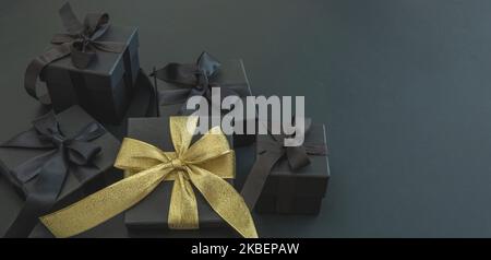 Black Friday Sale and Christmas presents. Gift boxes one with gold ribbon, copy space. Good buy, bargain concept. Stock Photo
