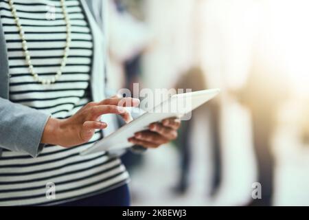 Productivity in her hands. an unrecognisable businesswoman using a digital tablet in an office. Stock Photo