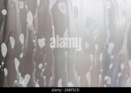 Wash the glass with foam background on the car Stock Photo