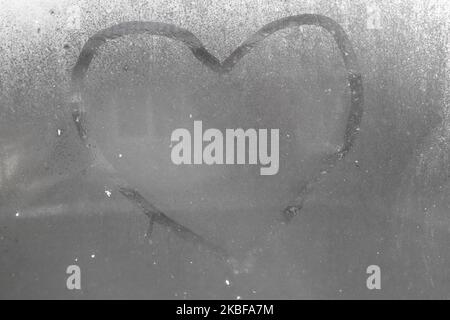 valentine's day concept of heart shape written on a foggy window and rain drops. Stock Photo