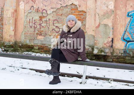 a woman was sitting in the winter on old street Stock Photo
