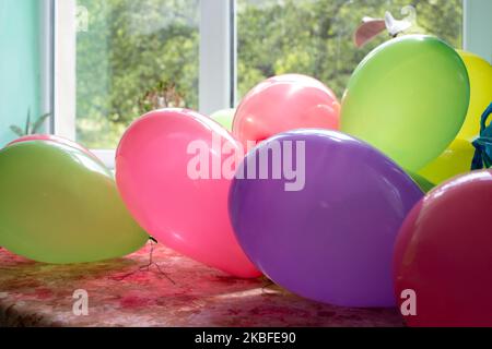 birthday balloons lying on a table on a background window Stock Photo