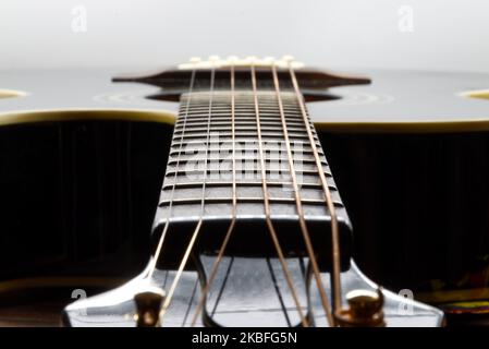 Acoustic black guitar isolated on white background, focus on fretboard Stock Photo