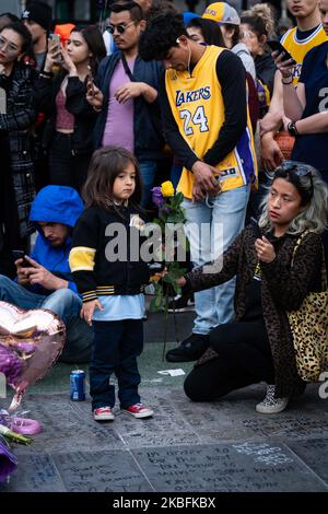 A mother and daughter leave flowers at a memorial in Los Angeles, CA on January 27, 2020. (Photo by Brent Combs/NurPhoto)