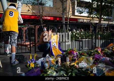 Fans gather at a makeshift memorial to mourn the death of NBA legend Kobe Bryant, who was killed along with his daughter and seven others in a helicopter crash on January 26, at LA Live plaza in front of Staples Center in Los Angeles on January 27, 2020. - (Photo by Brent Combs/NurPhoto)