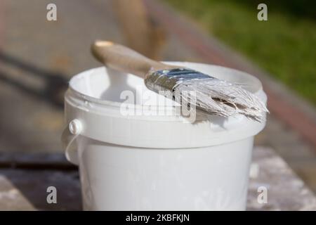 Paint brush resting on paint tin viewed from above Stock Photo