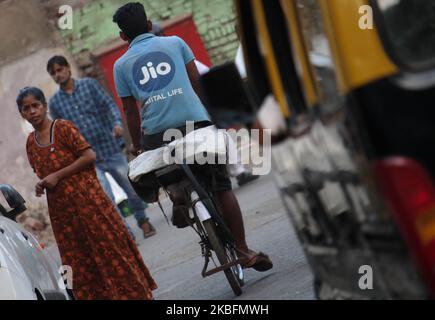 A man wearing a T-shirt with the logo of Reliance Jio Infocomm Ltd rides a bicycle in Mumbai, India on 28 January 2020. (Photo by Himanshu Bhatt/NurPhoto) Stock Photo