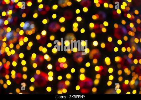 Blurred Christmas lamps on Christmas tree. Defocused yellow, red lights. Copy space Stock Photo