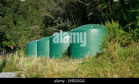 Water storage tanks on a hilltop on a rural property, Aotearoa / New Zealand. Stock Photo