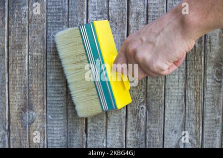 hold the brush in hand on the wall panel Stock Photo