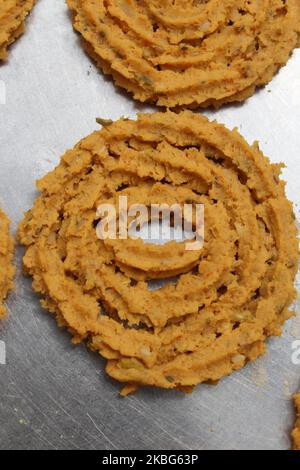 Raw chakali in plate. Indian Traditional Tea Time Snack Chakli, a deep fried snack, It is known as Chakali, Murukku, Muruku, Murkoo, Chakri. Stock Photo